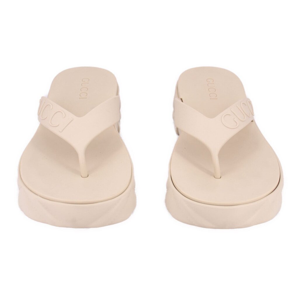 Cream rubber GUCCI flip-flop sandals, pair view showing embossed logo on straps