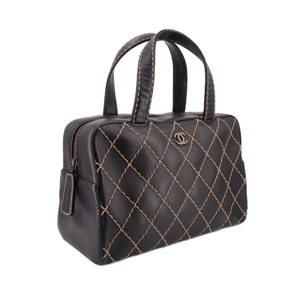 Black quilted handbag with two top handles and gold diamond stitching, side view
