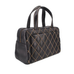 Black quilted mini handbag with gold lattice stitching and top handles, angled view