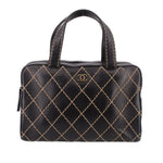 Black structured handbag with rounded top handles, gold diamond stitching, and CHANEL emblem