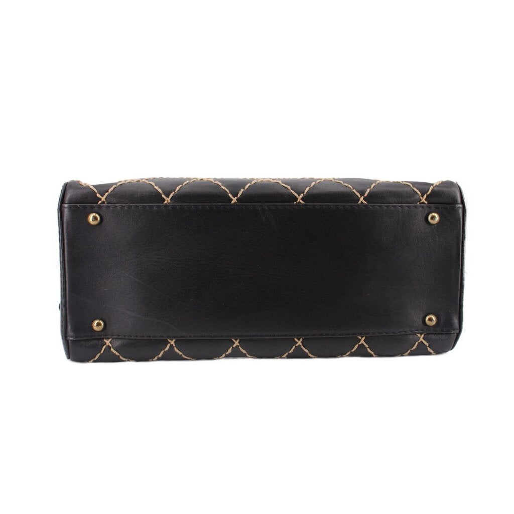 Black quilted handbag back panel with gold-tone grommet snaps and stitched detailing