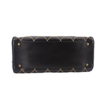 Black quilted handbag back panel with gold-tone grommet snaps and stitched detailing