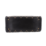 Black quilted handbag back panel with gold-tone grommet snaps and stitched detailing