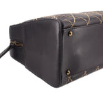 Black handbag side panel with gold-tone snap hardware and visible quilting stitches