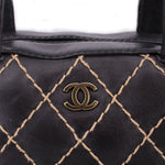 Black leather handle bag with diamond lattice stitching and CHANEL logo plaque