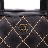Black leather handle bag with diamond lattice stitching and CHANEL logo plaque