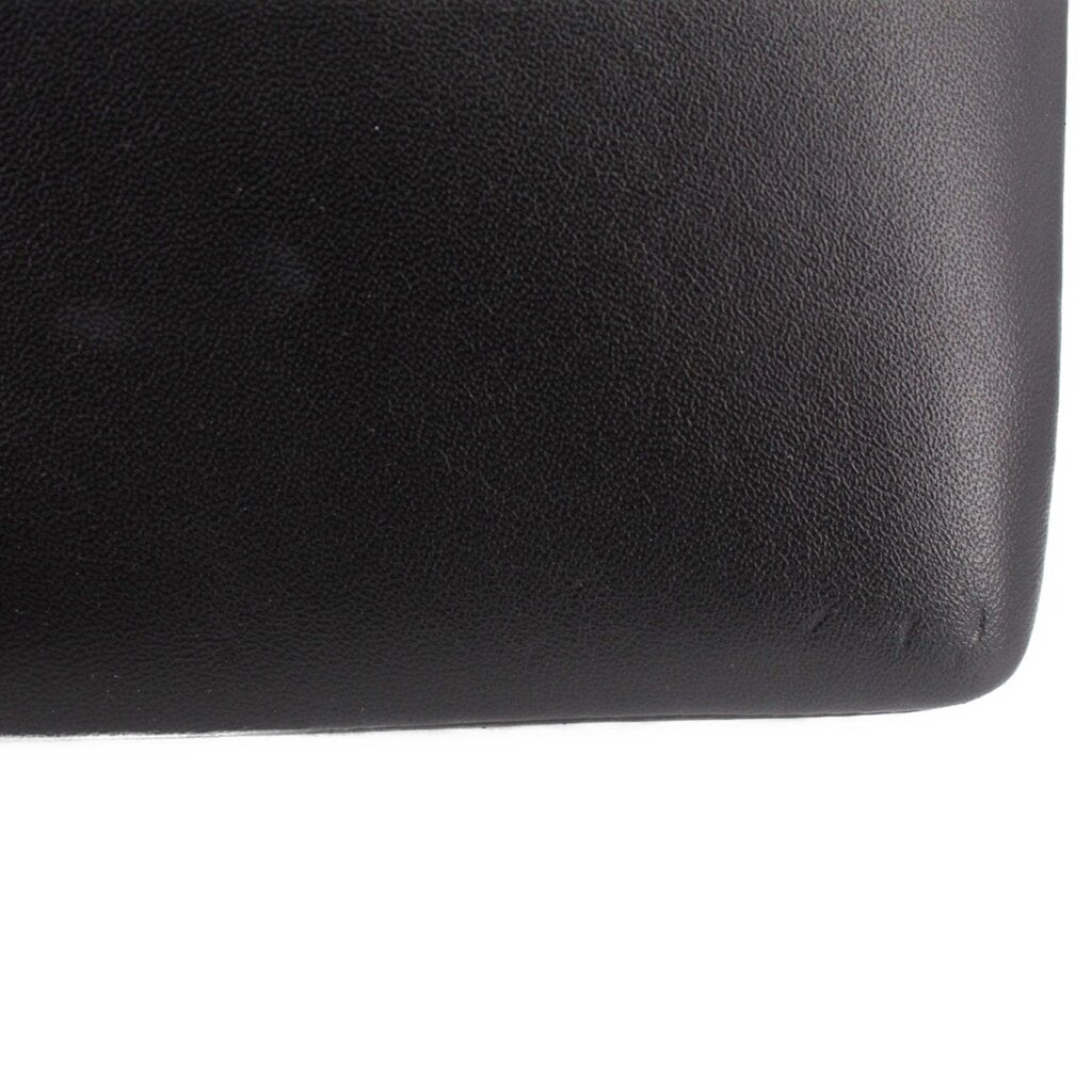 Black crossbody bag texture close-up on the side panel