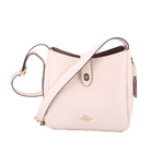 Cream leather crossbody bag with front slip pocket and adjustable shoulder strap.