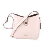 Cream leather crossbody bag with front slip pocket and adjustable shoulder strap.