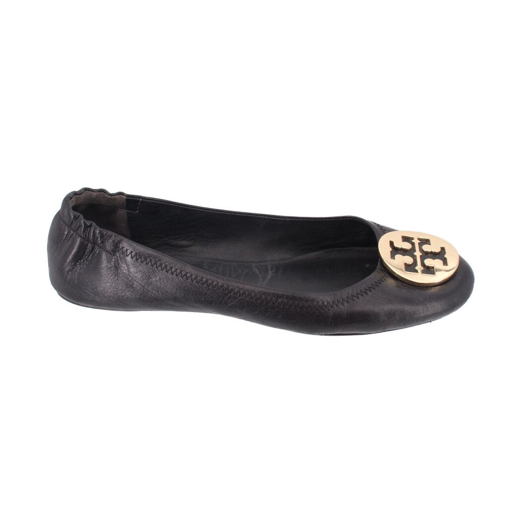 Black leather ballet flats, side view with gold logo medallion on toe