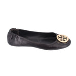 Black leather ballet flats, side view with gold logo medallion on toe
