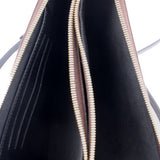 Interior of double-zip crossbody pochette with black lining and gold zipper trim