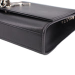 Black leather crossbody bag corner detail with stitched edge and clasp hardware