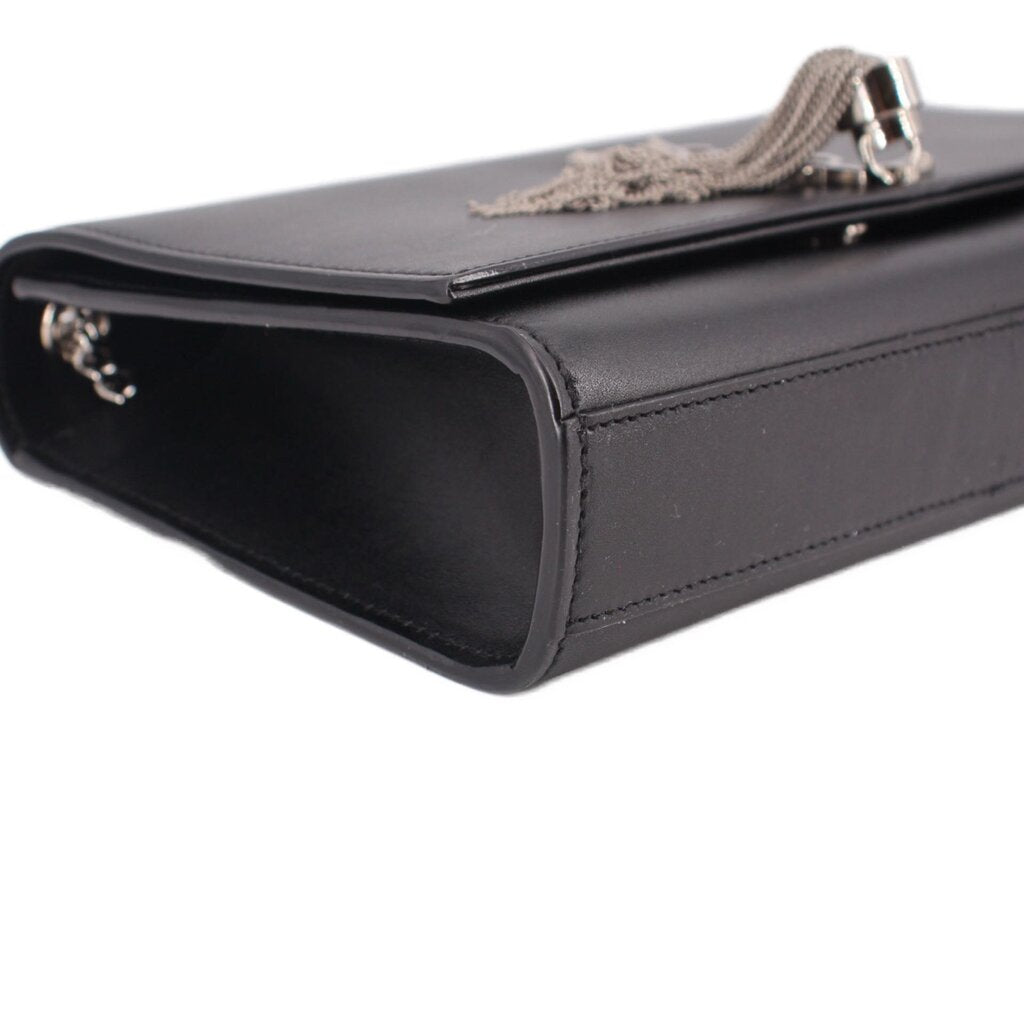 Black leather crossbody bag side view with chain strap hardware and tassel pull