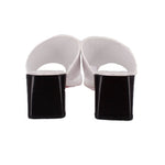 White slide sandals with black block heels and open heel back
