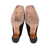 Black suede ankle booties showing logo insoles and rubber outsole