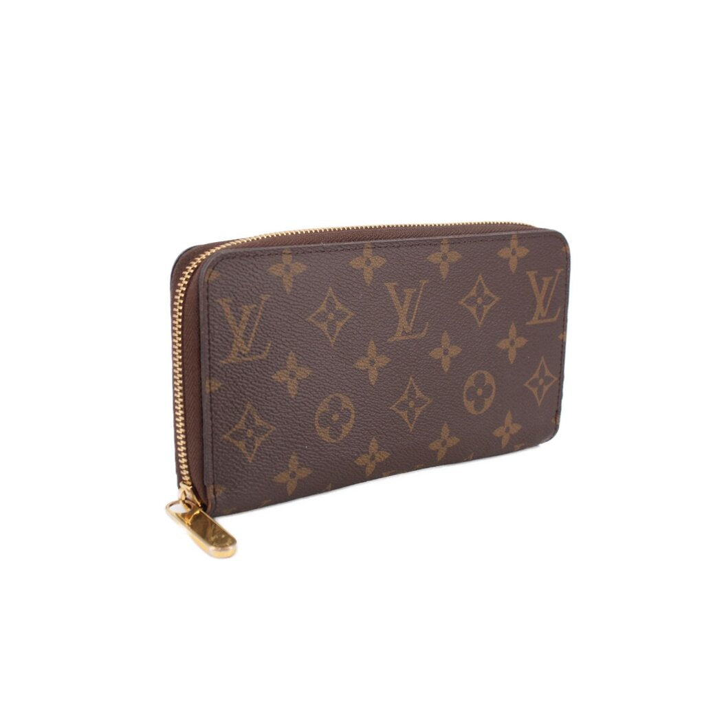 Zippy wallet in dark brown monogram canvas with gold-tone zipper and pull tab