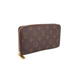 Zippy wallet in dark brown monogram canvas with gold-tone zipper and pull tab