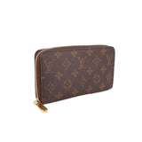 Zippy wallet in dark brown monogram canvas with gold-tone zipper and pull tab