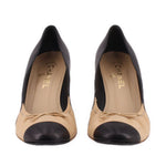 Pair of two-tone cap-toe kitten heels, nude/beige fronts with black toe caps