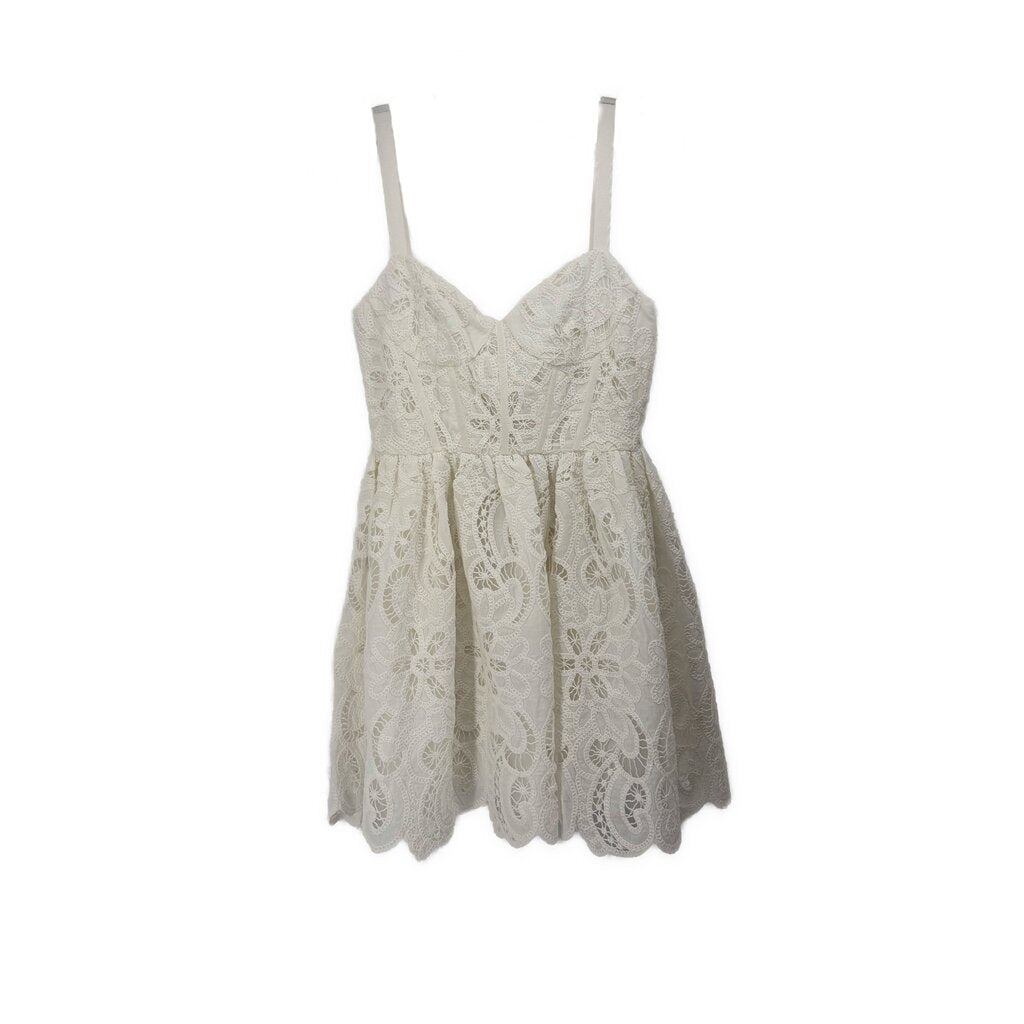 White lace baby-doll dress with spaghetti straps and scalloped hem