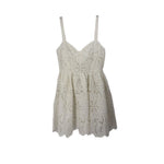 White lace baby-doll dress with spaghetti straps and scalloped hem
