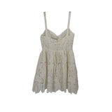 White lace sundress with spaghetti straps, gathered waist, and scalloped skirt hem