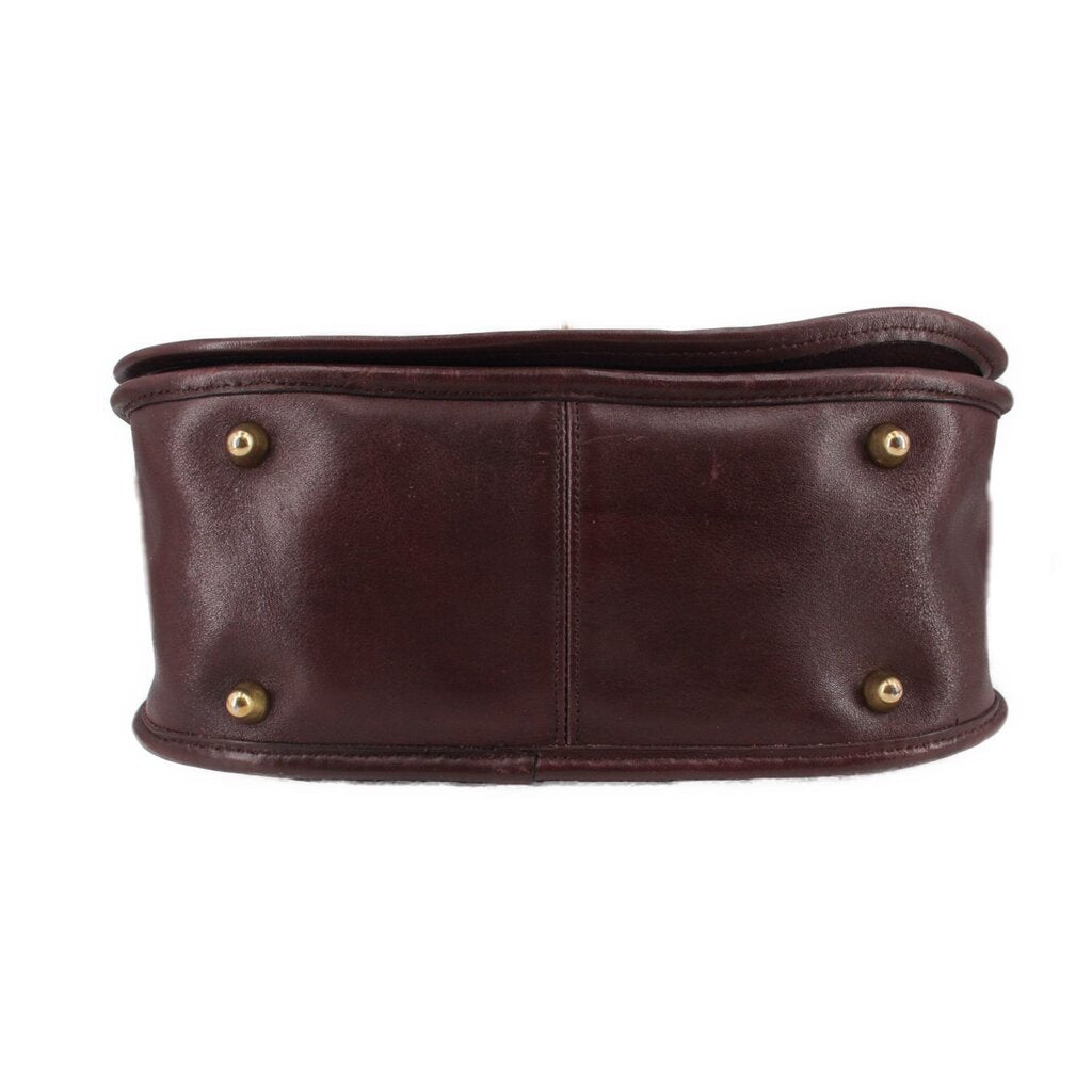 Oxblood leather COACH shoulder bag bottom edge with four gold-tone eyelets