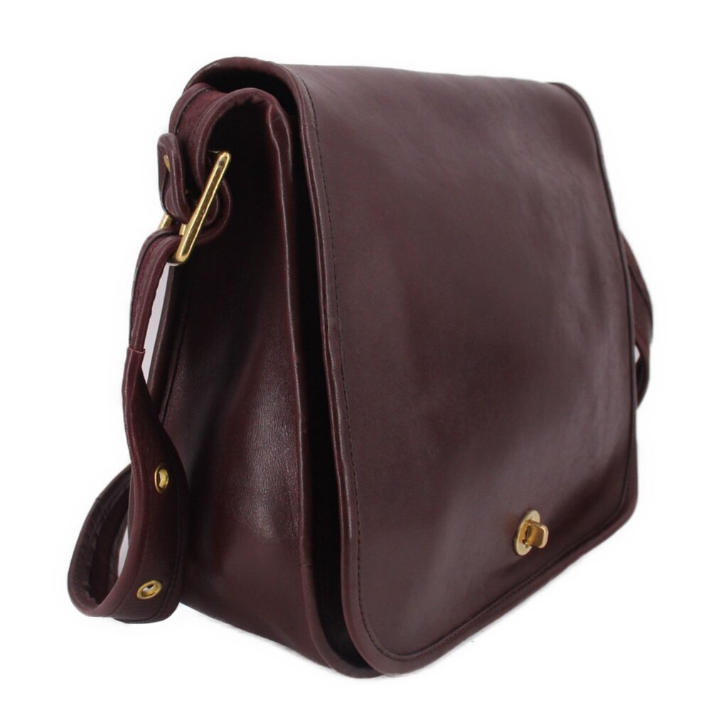 Oxblood leather COACH shoulder bag, side view with gold-tone hardware and strap loops
