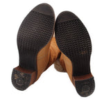 Brown suede boot soles and heels with textured tread and Chanel logo embossing