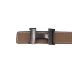 Taupe belt with double-tone H-style buckle, visible stitching and strap loops.