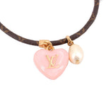 Pink LV heart charm with white pearl on gold monogram bracelet, close-up