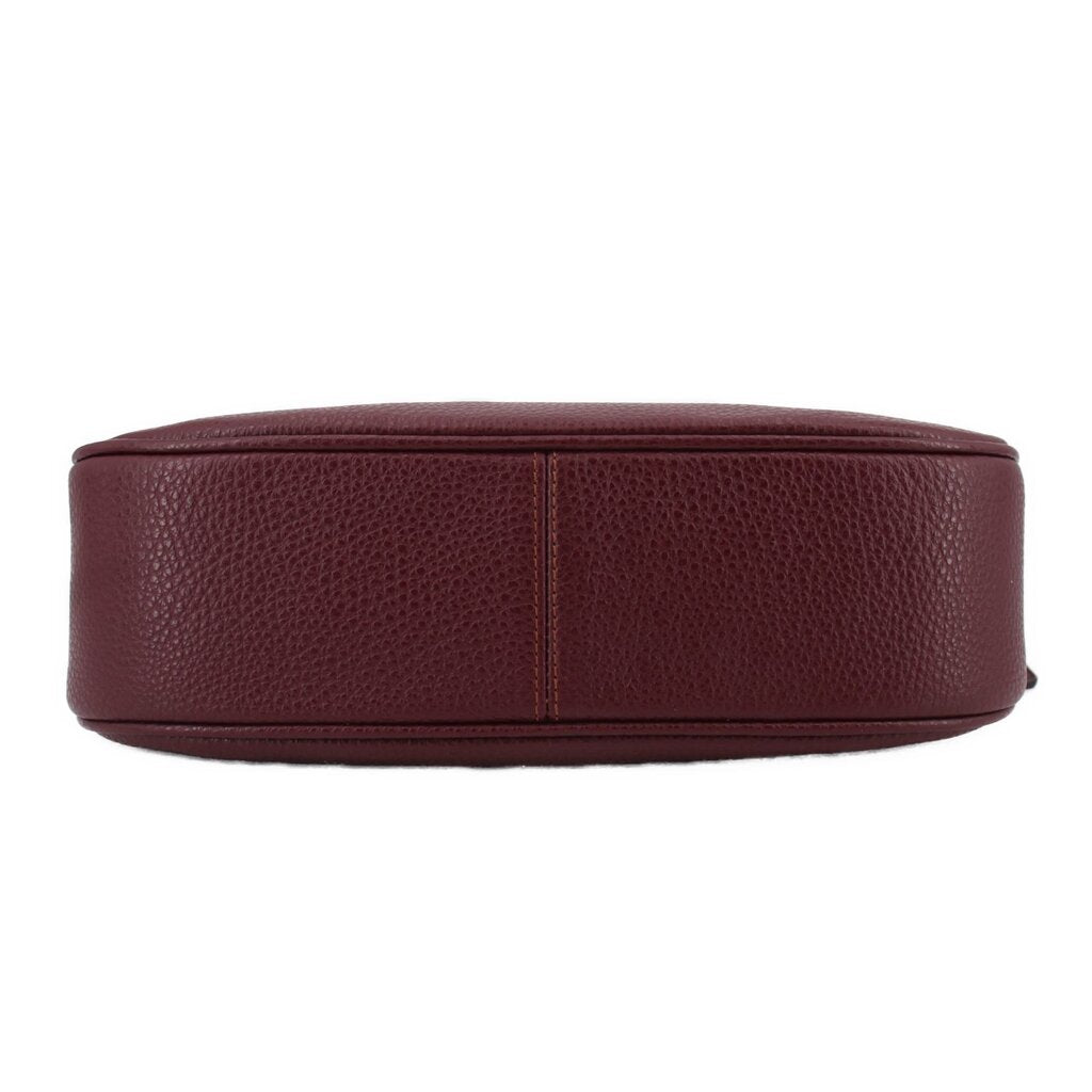 Merlot leather crossbody bag bottom view with stitched base seam and rounded shape.