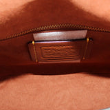 Leather crossbody bag interior label patch with gold-toned zipper trim, merlot finish.