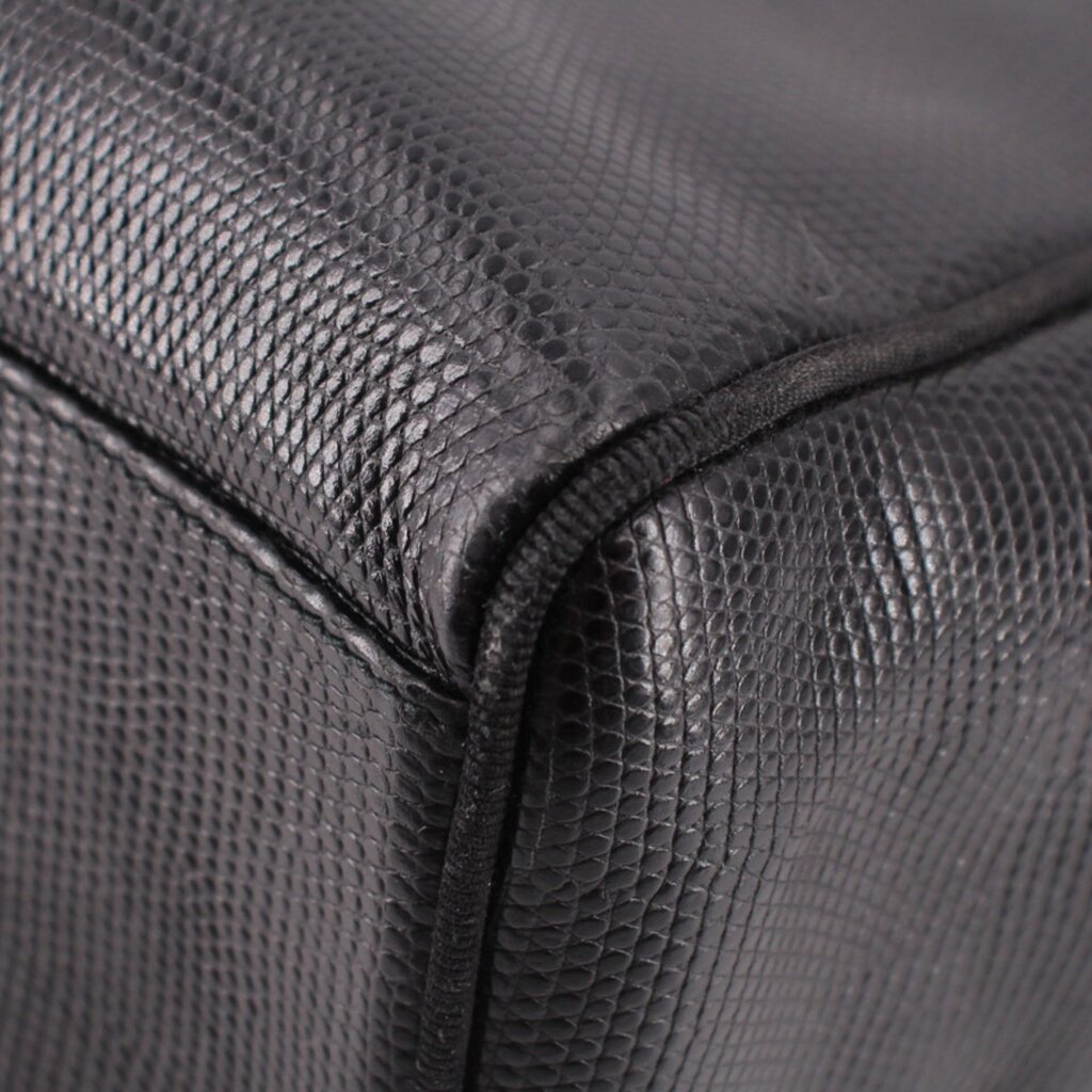 Close-up of black textured leather corner and stitched seam on vintage bag