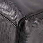 Close-up of black textured leather corner and stitched seam on vintage bag