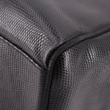 Close-up of black textured leather corner and stitched seam on vintage bag