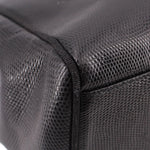 Close-up of black textured leather panel with stitched corner seam