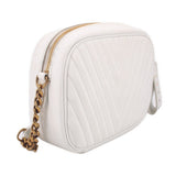 White quilted camera crossbody bag, three-quarter view with gold zipper and chain strap