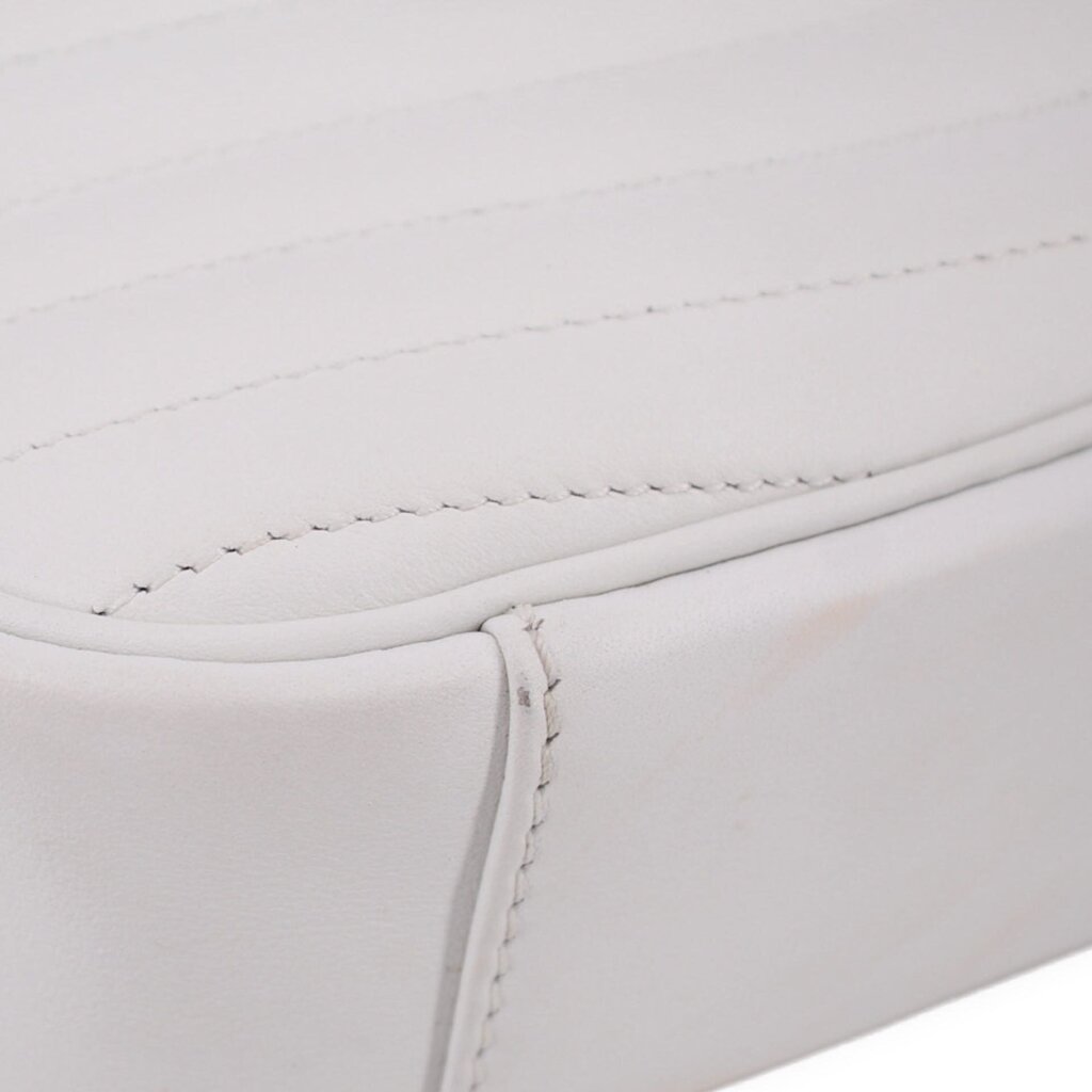 Close-up of white bag panel with stitched trim and curved seam detail