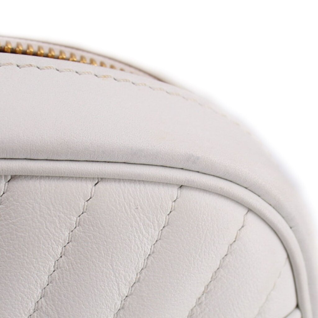 Close-up of white quilted panel with fine stitching and rounded top edge