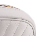 Close-up of white quilted panel with fine stitching and rounded top edge