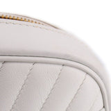 Close-up of white quilted panel with fine stitching and rounded top edge