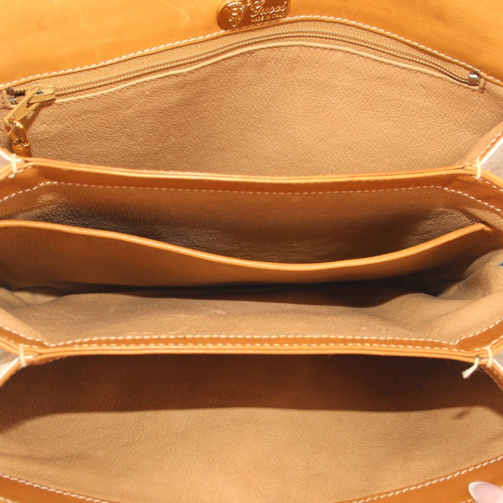 GUCCI crossbody bag interior view with tan lining and top zip opening