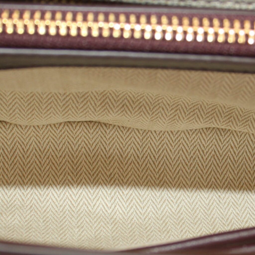 Beige woven interior lining with gold zipper trim at top edge