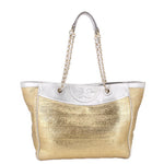 Gold raffia tote bag with silver logo panel and dangling chain handles