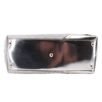 Silver tote bag front panel with gold-tone grommet snaps and textured leather edges