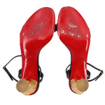 Black heeled sandals with red soles and gold heel details; slingback straps