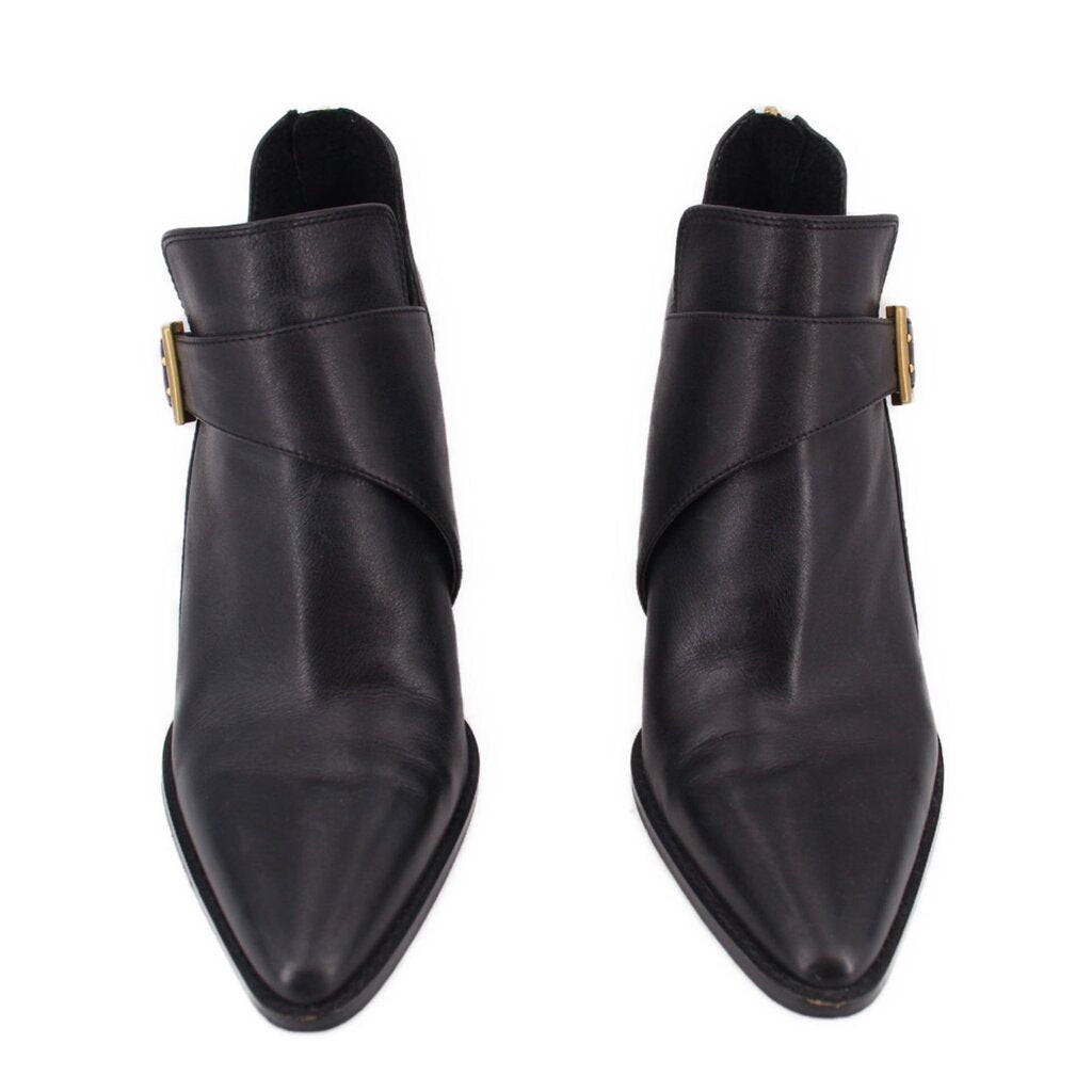 Pair of black ankle booties with side buckle closure and pointed toe