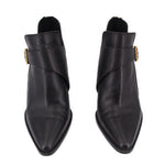 Pair of black ankle booties with side buckle closure and pointed toe